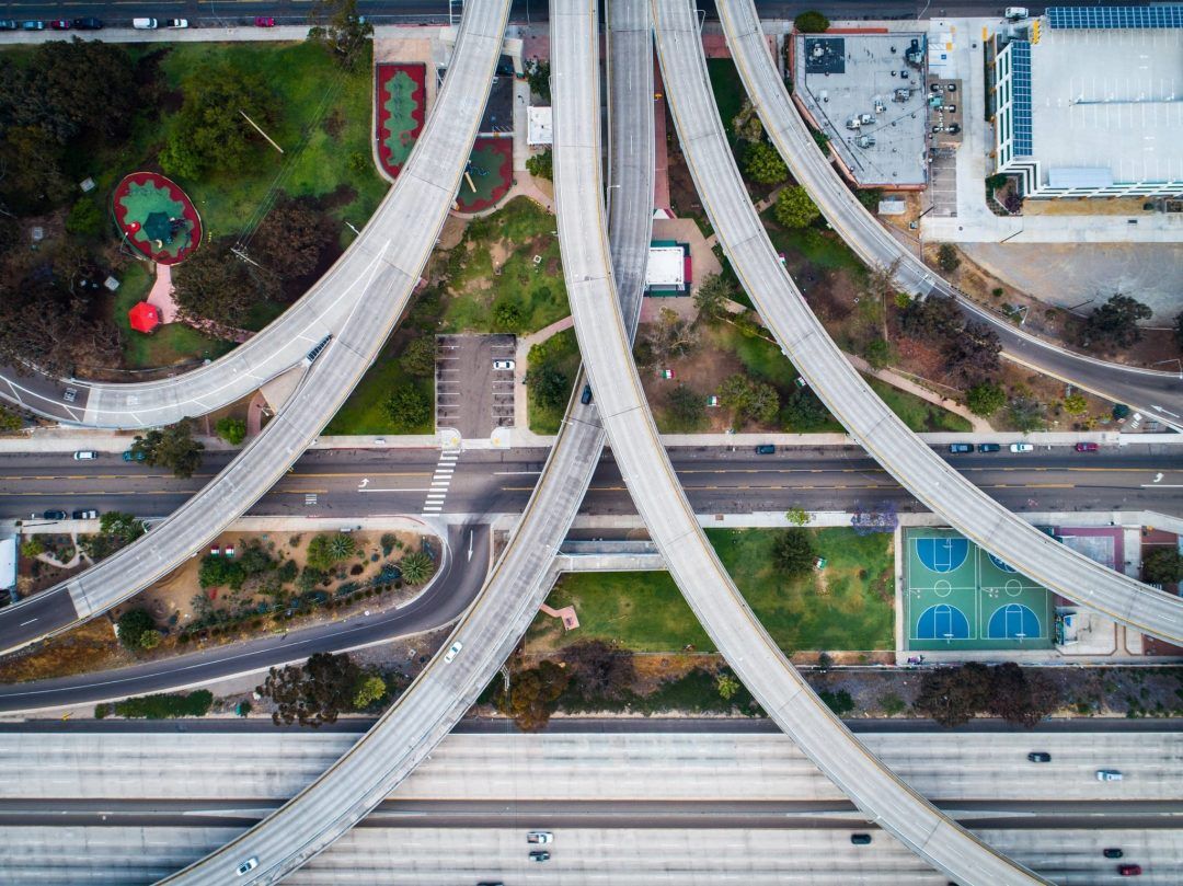 A bird's eye view of intersecting freeway overpasses over Chicano Park.