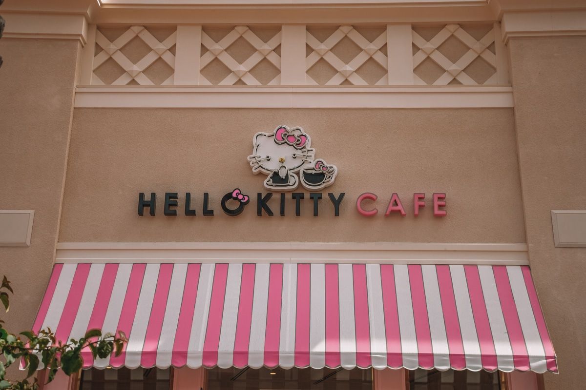 The pink and white striped awning and facade of the Hello Kitty Cafe.