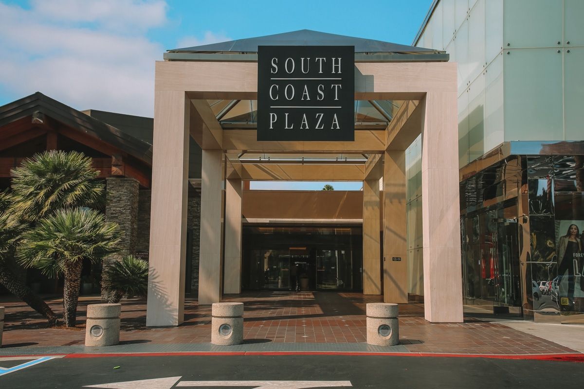 The entryway, sign, and brick sidewalk leading into the South Coast Plaza mall.