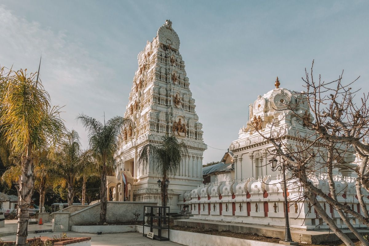 Malibu Hindu Temple, an ornate white and gold building surrounded by palm trees.