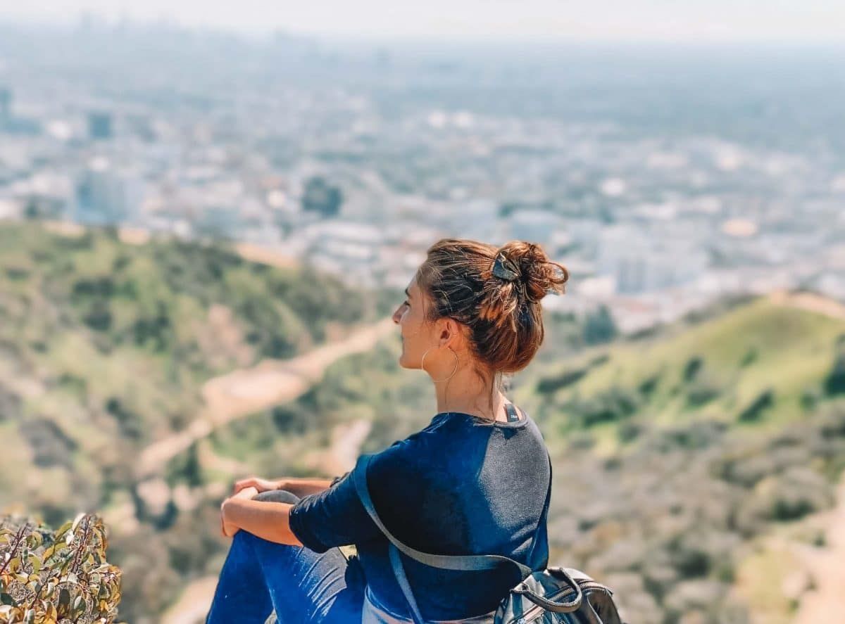 A woman with brown hair tied up in a clip, seen in three-quarter view and looking out from a vista in the Santa Monica mountains.
