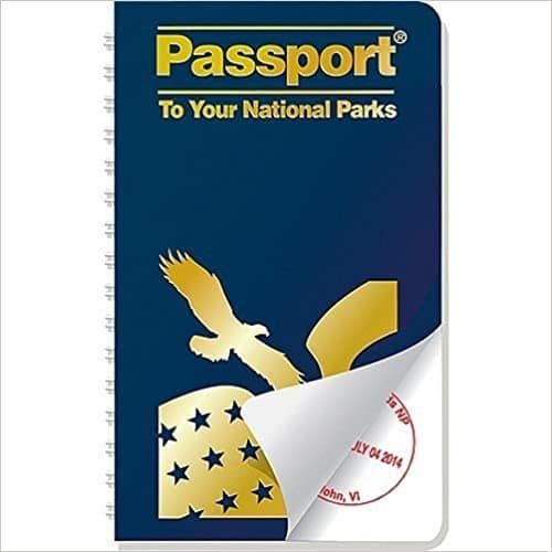 The front cover of the blue and gold National Park Passport with an eagle and a flag with stars on it.