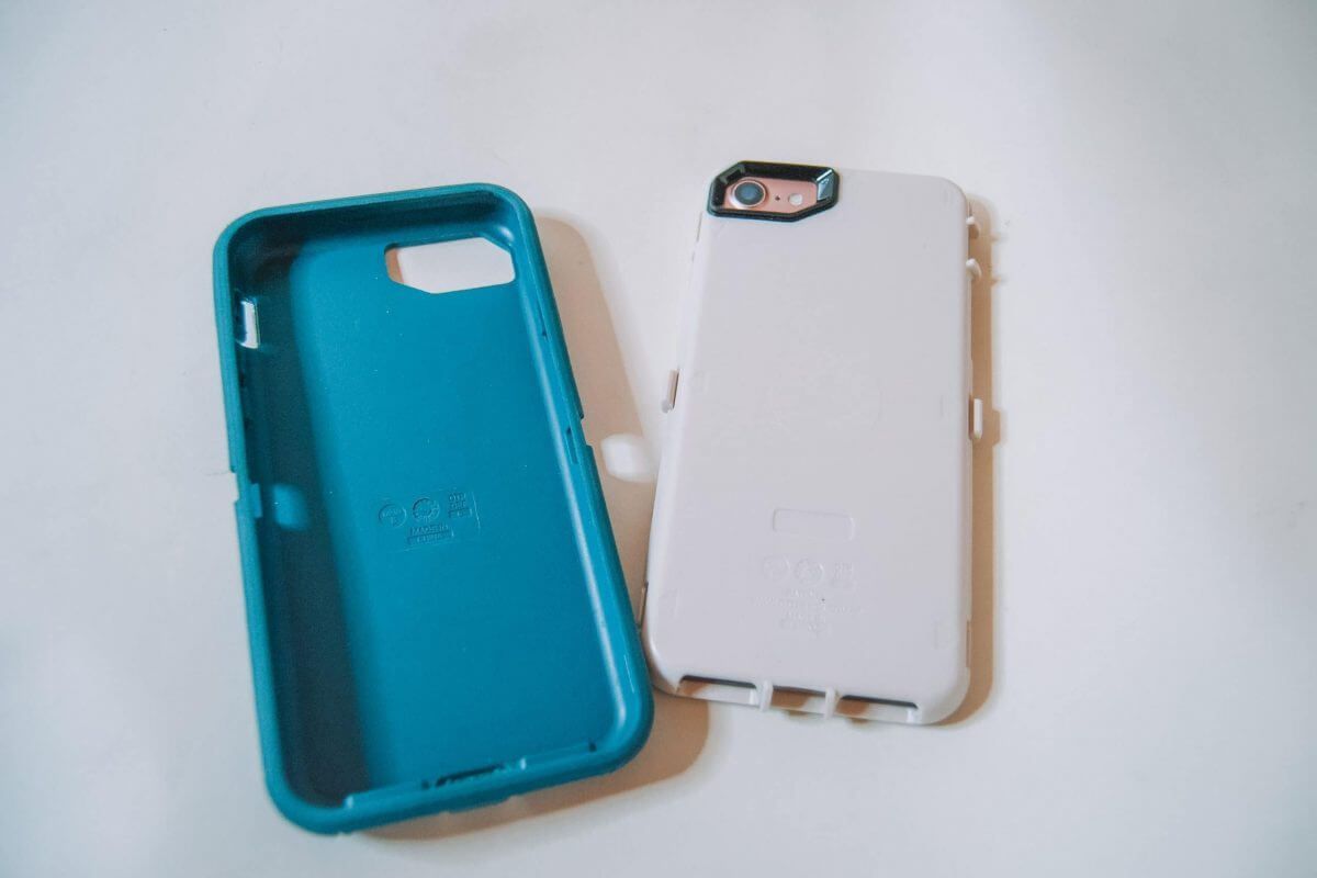 An Otterbox Defender phone case separated into two parts--inner and outer--lying on a white background.