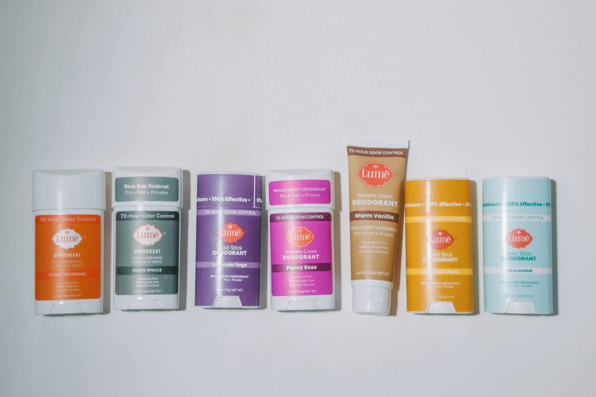 A full line-up of Lume deodorant in solid stick, cream stick, and cream tube varieties on a white background.