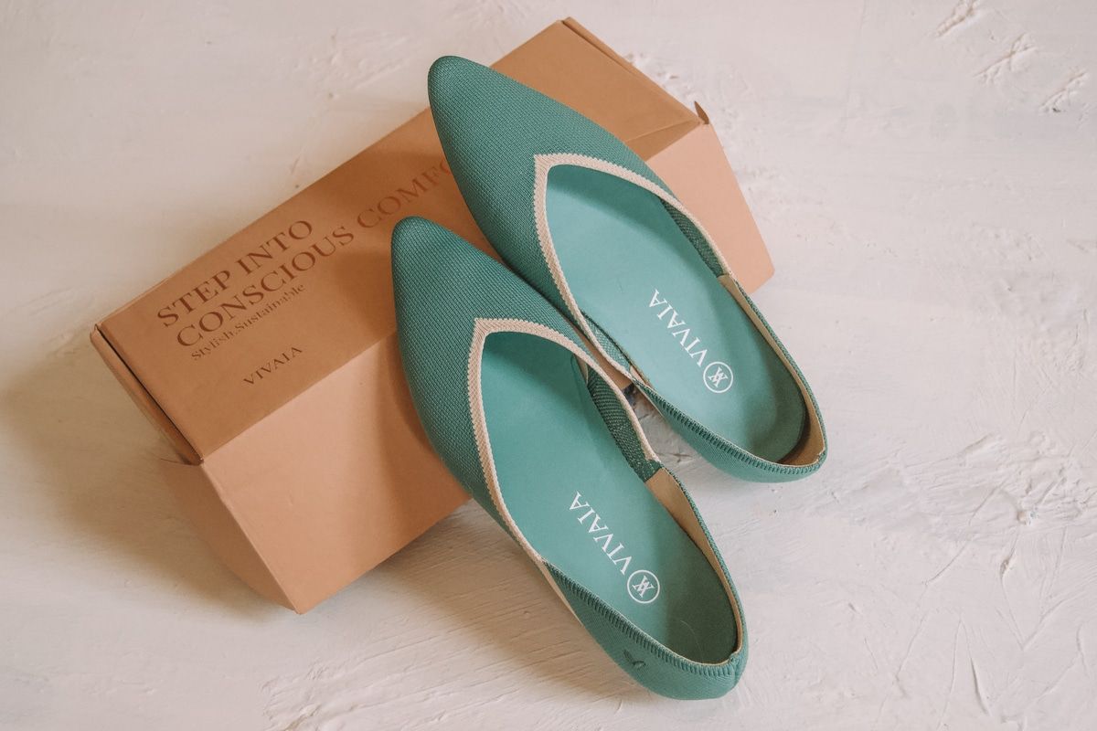 A pair of teal Vienna flats resting against the packaging they came in for this Vivaia shoes review.