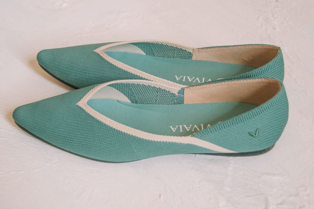 A pair of teal Vivaia flats sitting on a white background.