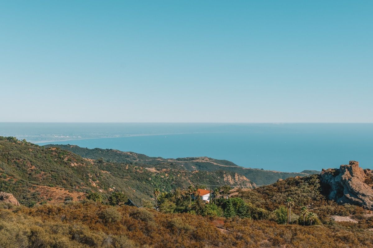A view looking out at craggy hills leading down towards the ocean at Topanga State Park.
