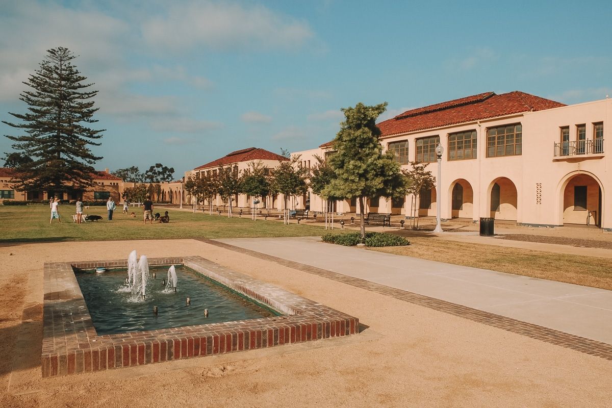 A manicured lawn and fountain outside a long, low, Spanish-style building in Liberty Station Park.
