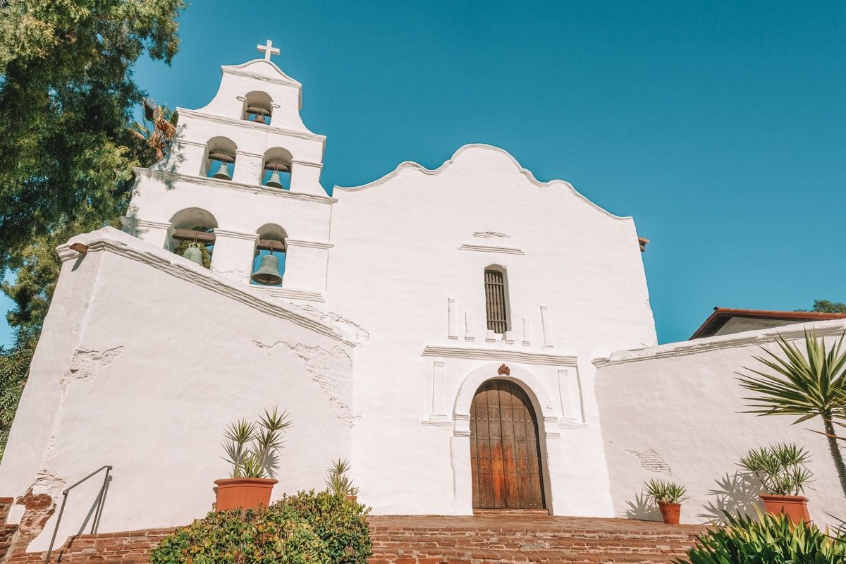 The whitewashed, spanish style facade of Mission Basilica San Diego de Alcala.