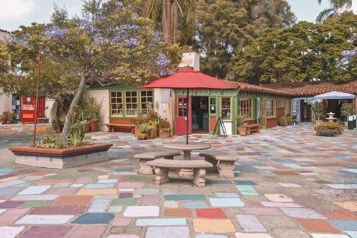 Multicolored cobblestones and a low cottage art studio in the Spanish Village Artist Center.