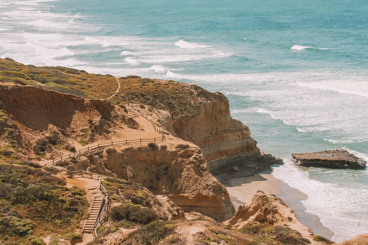 A path leads to sandy cliffs overlooking the beach at Torrey Pines State Natural Reserve.