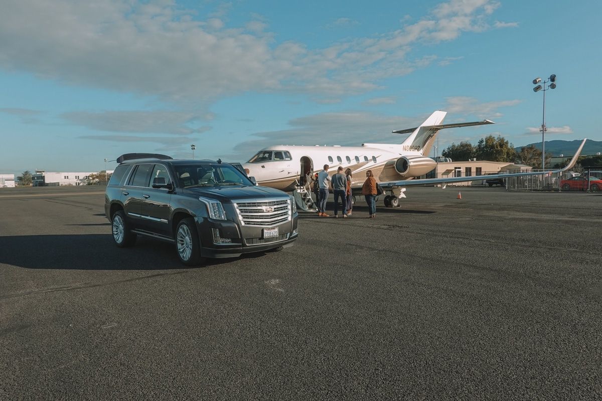 A small private plane and a black SUV on the tarmac at Napa County Airport.