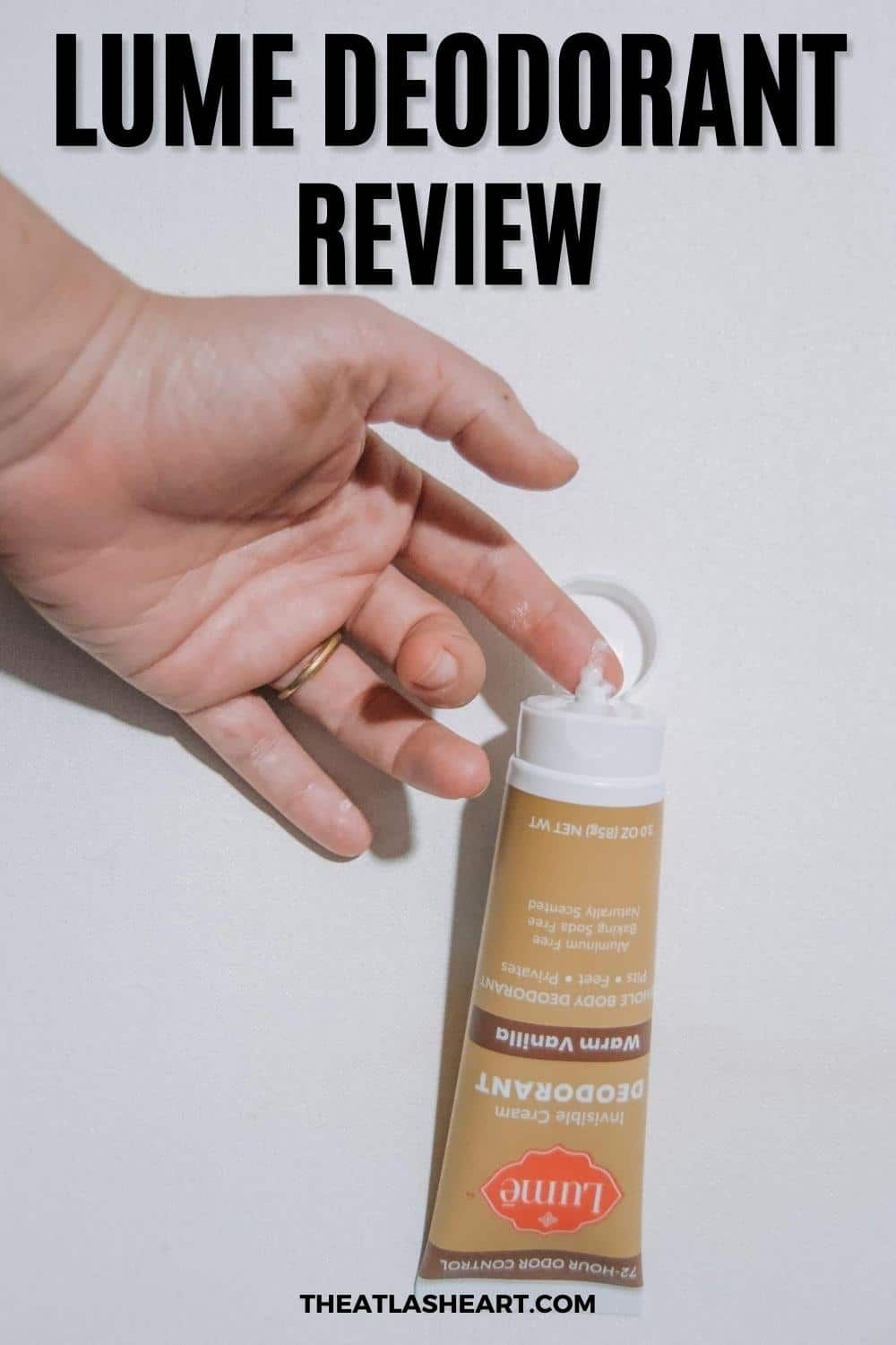 A hand takes a dollop of a Lume cream deodorant from a brown tube against a white background, with the text overlay, "Lume Deodorant Review."