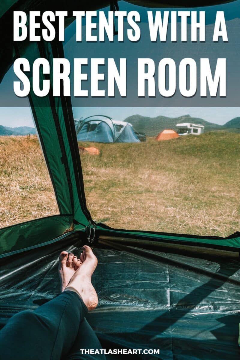 A view from inside a tent screen room with a pair of bare feet crossed in the foreground and a field with two other pitched tents visible through the screen, with the text overlay, "Best Tents With a Screen Room."