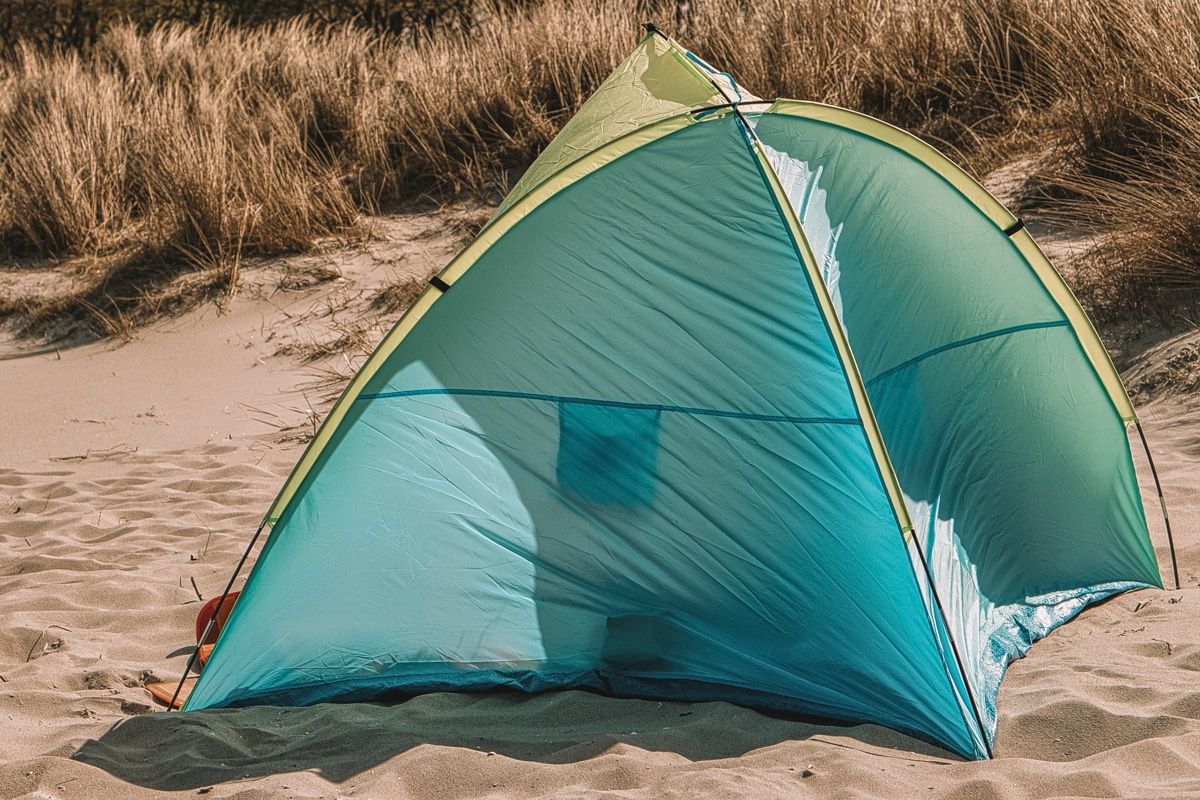 A small blue tent pitched on tent, contorted as it blows in the wind.