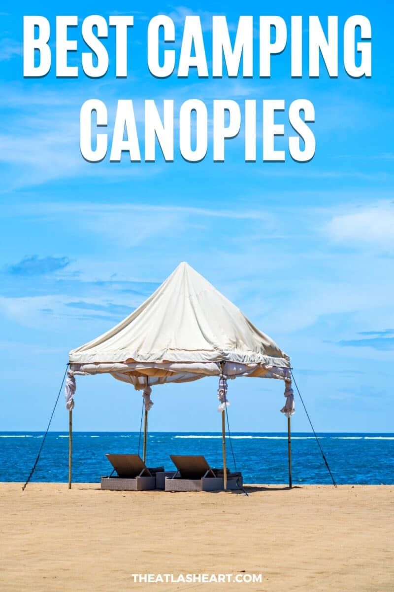 A canvas freestanding camping canopy pitched on a beach with two beach loungers underneath it, and the text overlay, "Best Camping Canopies."