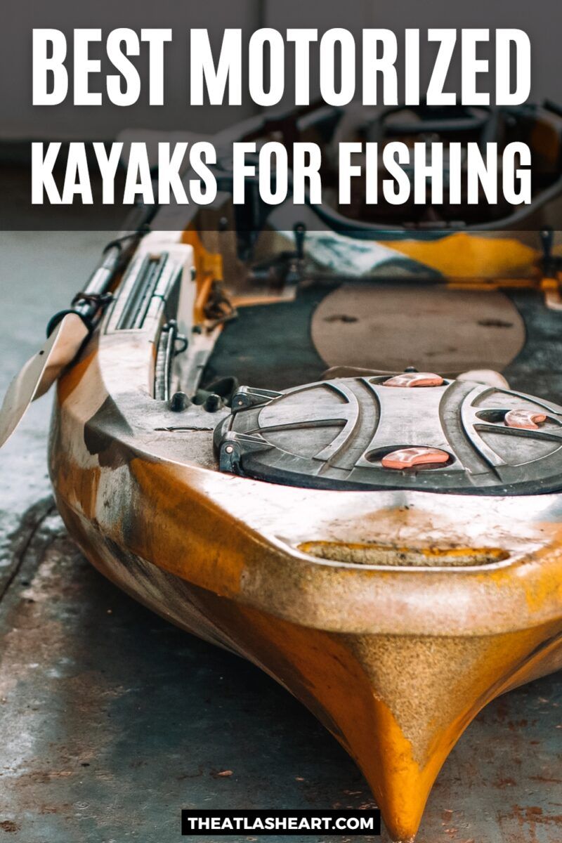 A foreshortened view of one of the best motorized kayaks sitting on the floor of a garage with a yellow finish, bathed in cool sunlight, with the text overlay, "Best Motorized Kayaks for Fishing."