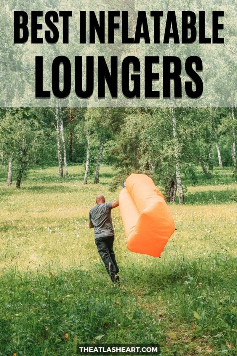 An orange lounger being inflated by a man who is running through a meadow, trailing the lounger, towards some sparse woods, "Best Inflatable Loungers."