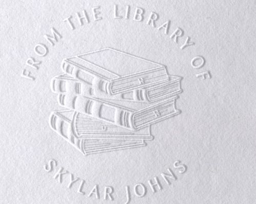 An embossed image of a stack of books with the text "From the Library of Skylar Johns"