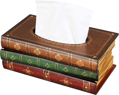Three fake books stacked on top of one another with tissues coming out of the whole in the top.