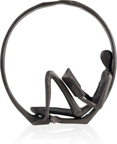 An iron circle with a lanky person on the inside, leaning up against the circle, reading.