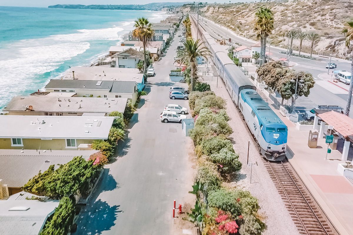 A view from above of the Amtrack train running through a California Beachside community on a sunny day.