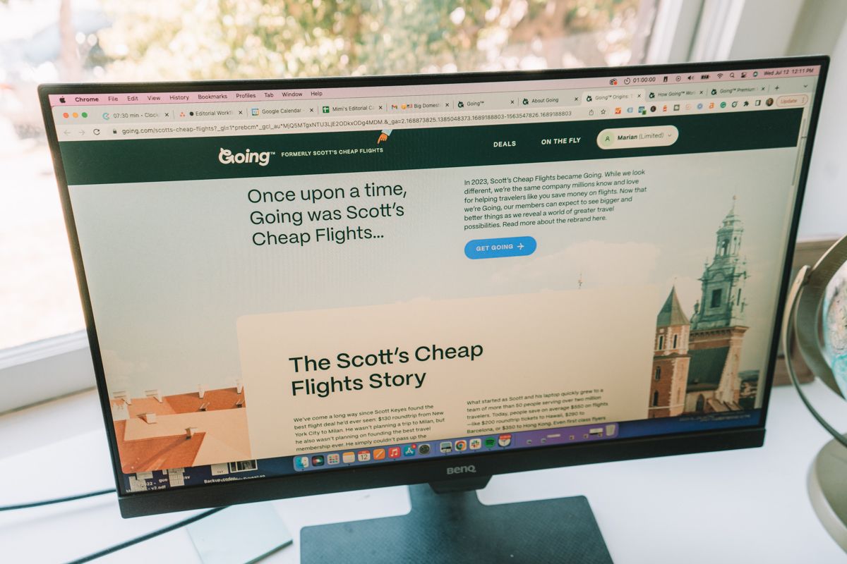 The Scott's Cheap Flights (now Going) homepage on a computer monitor on a white desk.