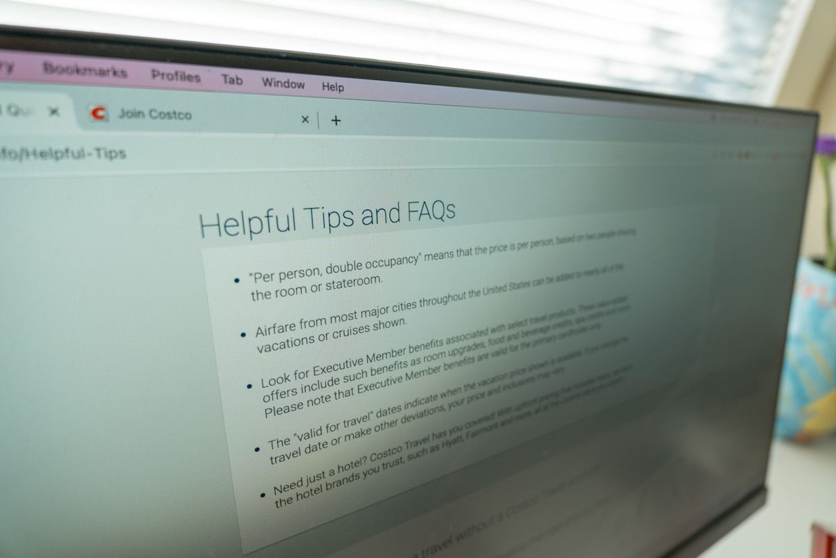 A close-up, angled shot of a computer screen displaying the "Helpful Tips and FAQs" page on the  Costco Travel website.