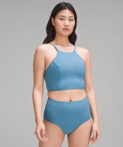 Product photo for the Lululemon Ribbed High-Neck Longline in blue, modeled by a woman with mid-length black hair. 