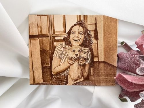 Product photo for the Portrait on Wood, showing a photo of a young woman holding a dog transferred onto a wooden panel.