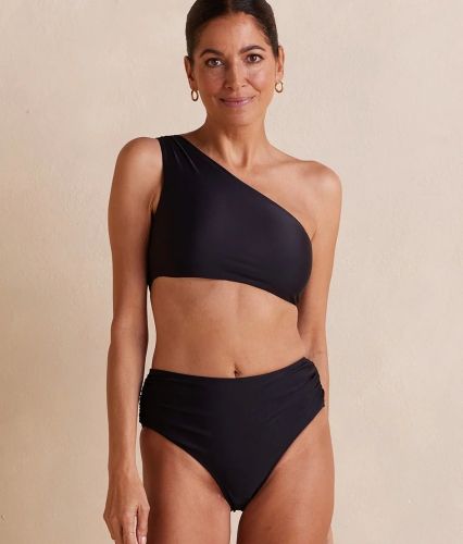 Product photo for the Summersalt Ruched Sidestroke Bikini Top, modeled by a dark-haired woman with her hair pulled back. 