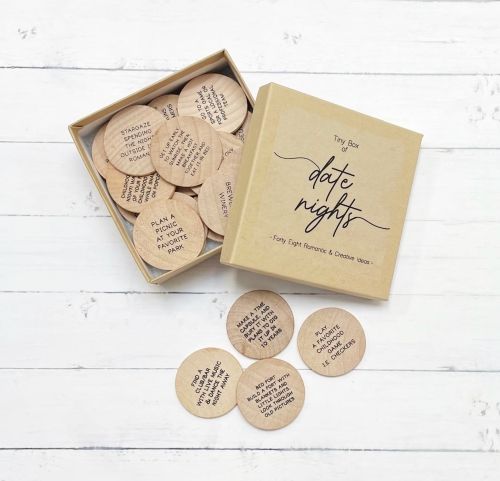 Product image for the Tiny Box of Date Night Tokens; a cardboard box filled with round wooden tokens.