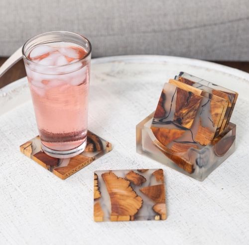 Product photo for the Wooden Coasters, pictured with a tall glass of iced, translucent, pink liquid.