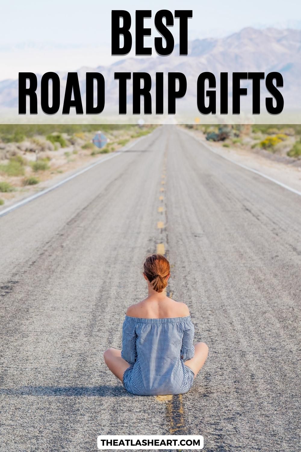 Best Road Trip Gifts Pin
A Pinterest pin with an image of a girl sitting cross-legged on an empty road in the middle of nowhere , with mountains in the background and the overlay text, "Best Road Trip Gifts."