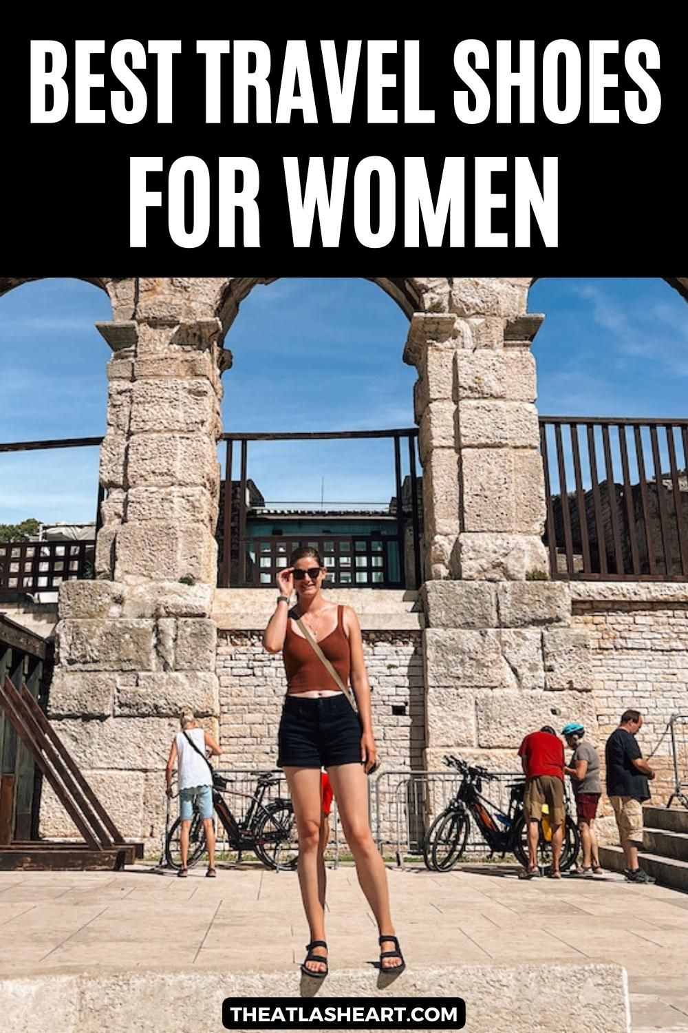 A young woman wearing black shorts, a burnt orange tank top and black sandals stands in front of the Roman Colosseum, with the text overlay, "Best Travel Shoes for Women."