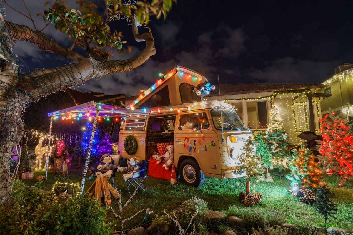 Candy Cane Lane – El Segundo
A white VW bus is parked in the middle of a grassy lawn and decorated with Christmas lights and stuffed bears who sit in champing chairs beside a make-believe campfire.