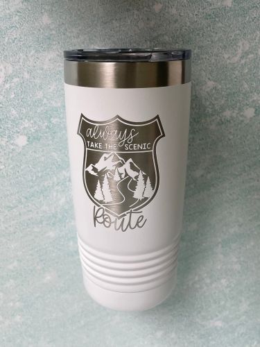 Engraved Tumbler
A white tumbler with a silver engraved logo shaped like a highway sign with mountains, trees, and a scenic road and the text, "Take the scenic route" for keeping beverages hot or cold on long drives.