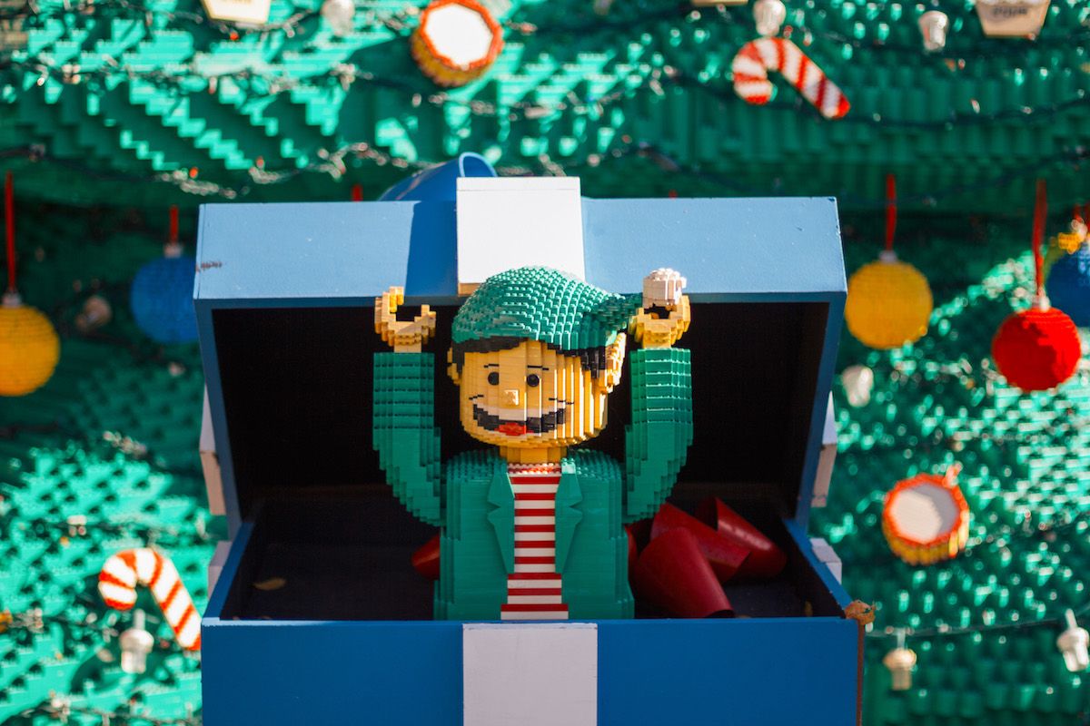 A lego sculpture of an elf popping out of a blue gift box in a display at the Holiday BRICKtacular at Legoland.