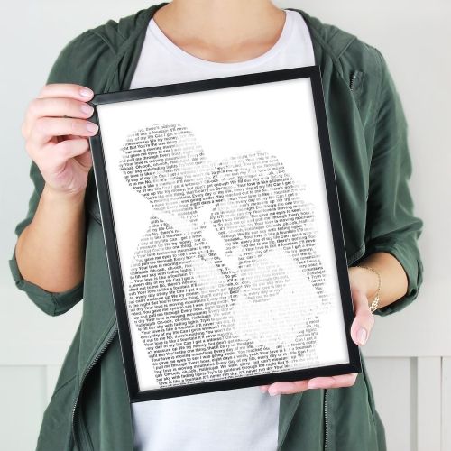 Product image for the Wedding Song Lyrics Wall Art held by a woman wearing a green hoodie.
