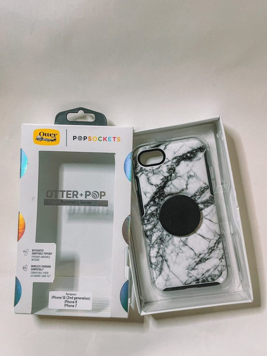 A white marble print Otterbox Symmetry phone case in partially-opened packaging on a white background.