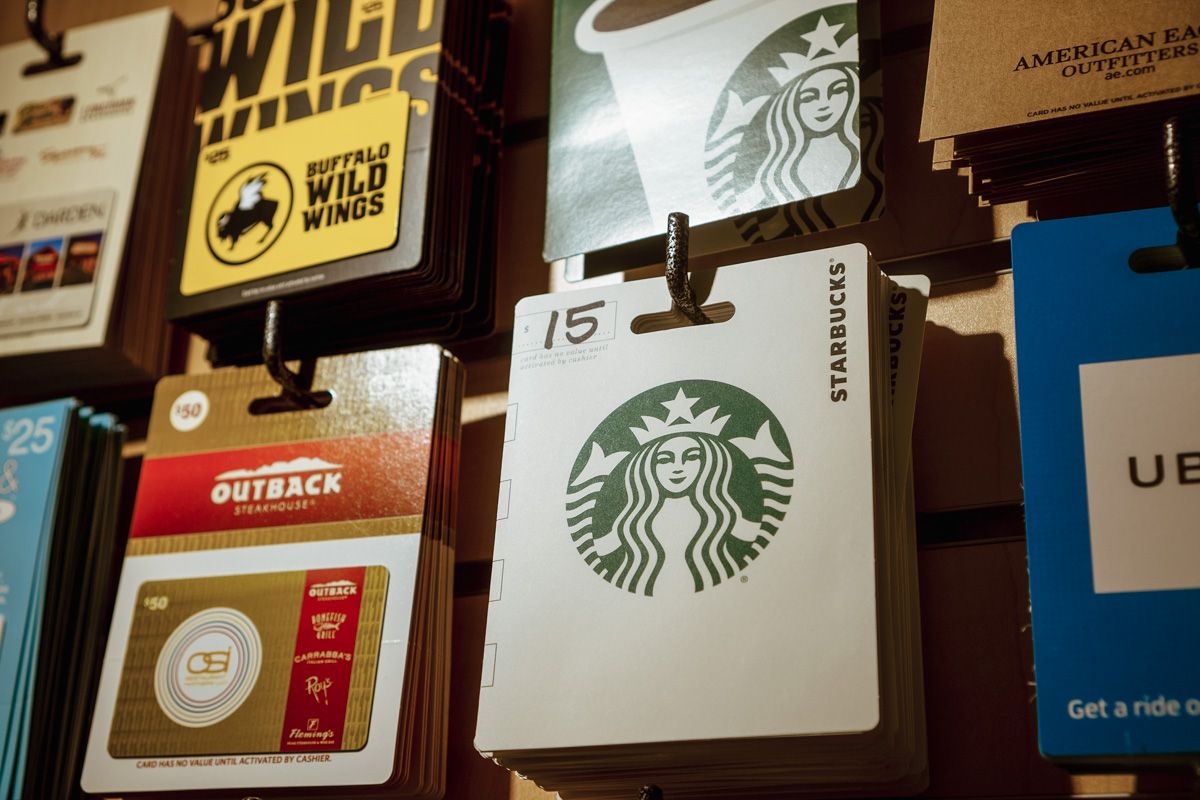 Various gift cards to Starbucks, Outback, etc., displayed on hooks on a wall.