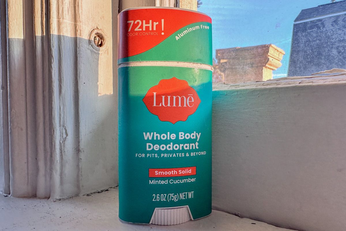 A stick of Minted Cucumber Lume deodorant sitting on a windowsill, with a blue sky visible through the pane.