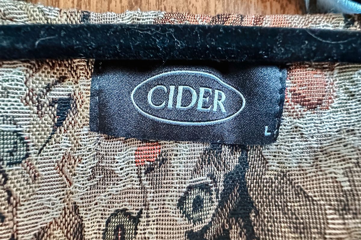 A close-up shot of a Cider clothing label, marked size L.
