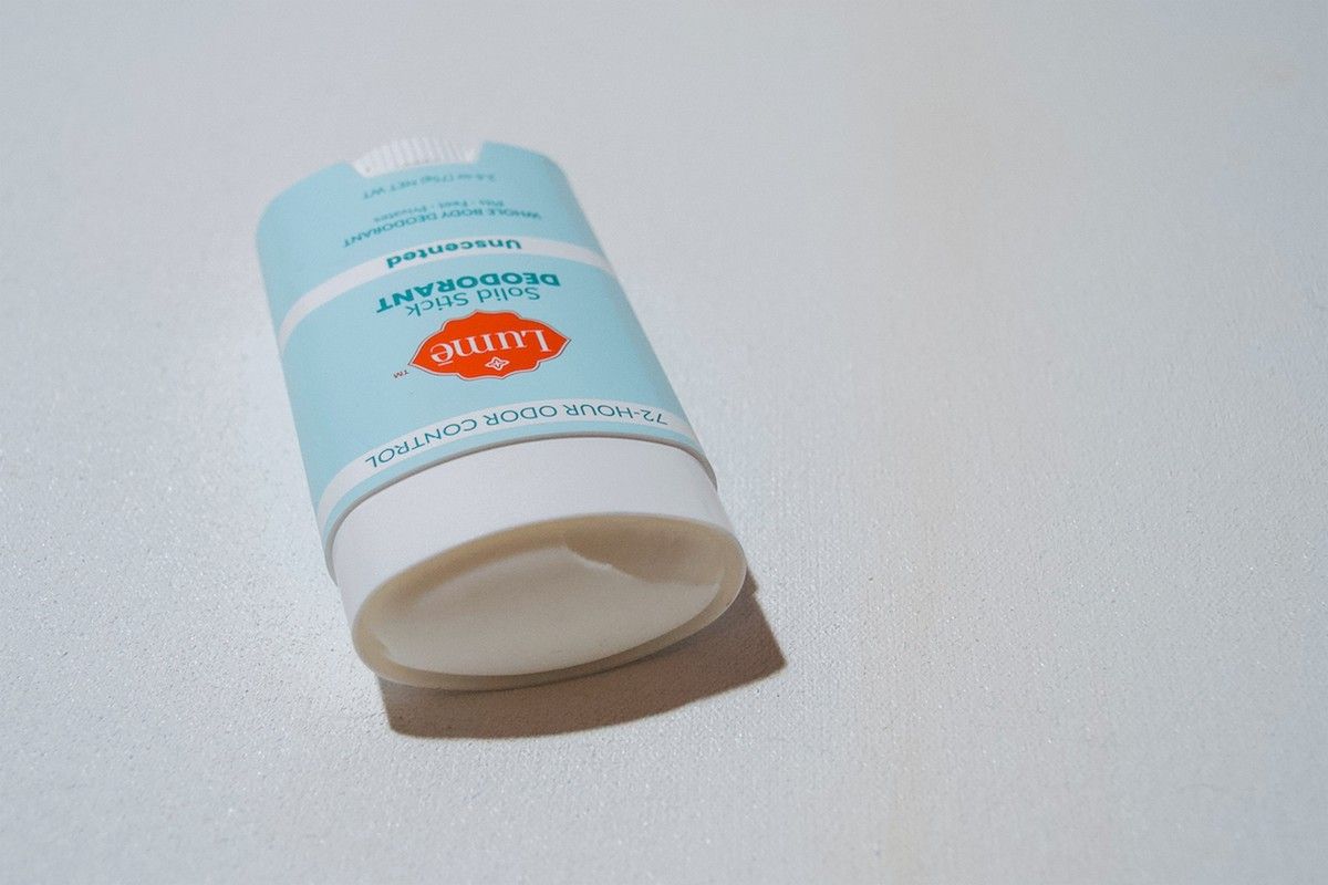 A stick of Unscented Lume deodorant lying on a white background.