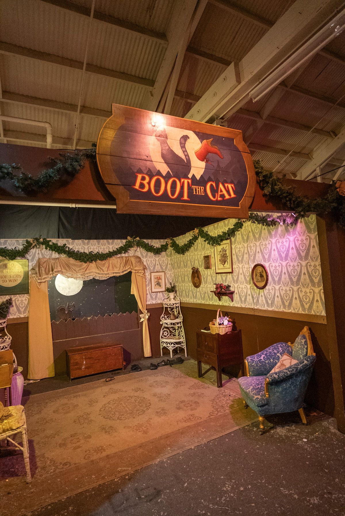 A Victorian-style Carnival Games booth with a sign that reads, "Boot the Cat."