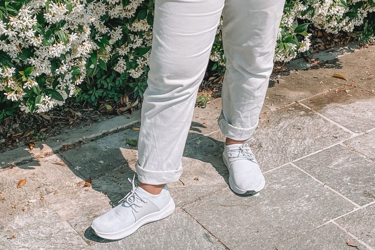 Close up of white wearing white Vessi shoes with white pants.