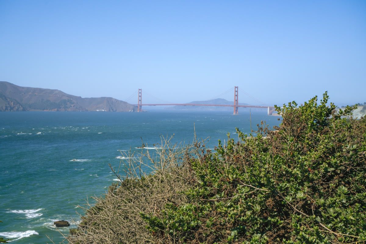 A view of the Golden Gate Bridge over the Bay on a clear day.